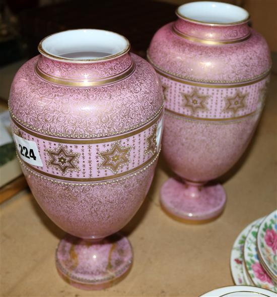 A pair of Continental enamelled glass pink ground vases and covers